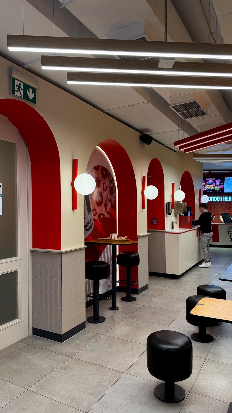 KFC VN40 — red arched seating niches with globe sconces and tiled wainscot