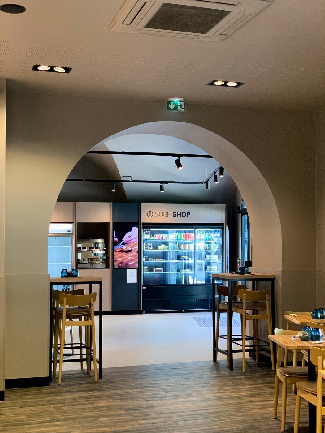 Sushi Shop Nîmes — arched opening framing the counter and chilled display