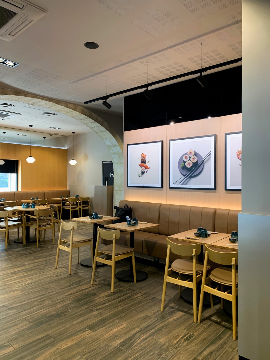 Sushi Shop Nîmes — oak dining room with leather banquette and framed sushi photography